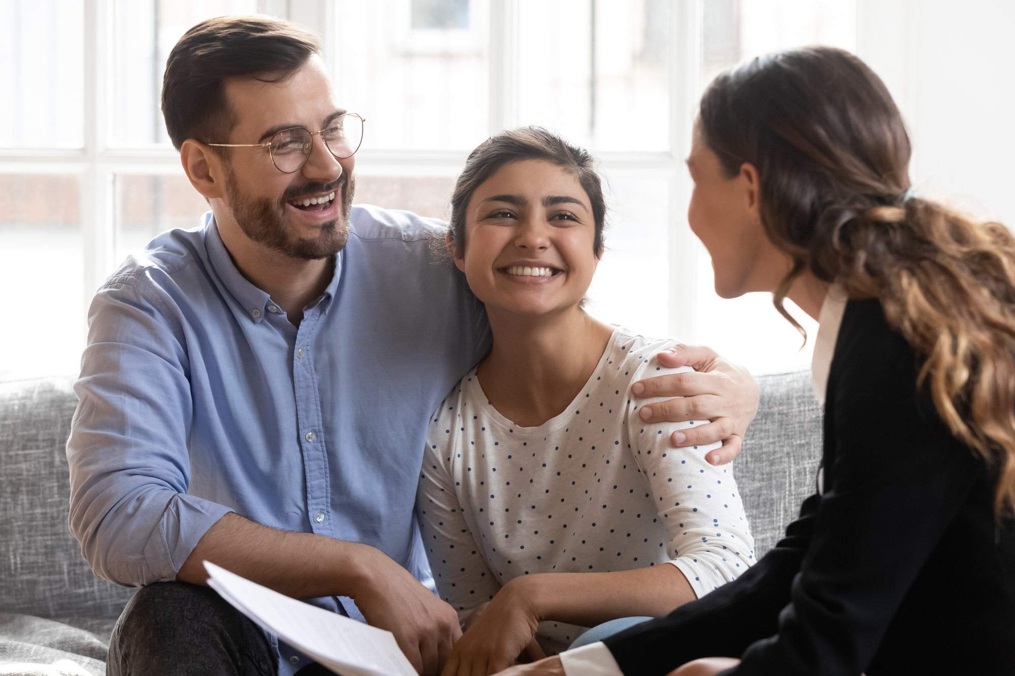 Happy Couple Talking With Female Real Estate Agent